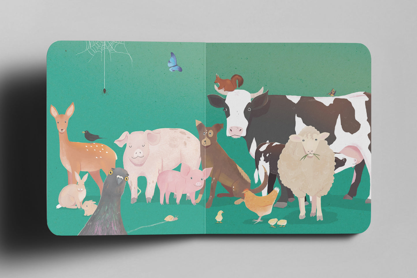 Kinderbuch-Doppelseite mit einer Illustration verschiedener sog. Nutztiere auf grünem Hintergrund. In der Mitte stehen ein rosa Schwein mit einem Ferkel, ein brauner Hund, eine schwarz-weiße Kuh und ein wolliges Schaf. Links ist ein Reh, eine Taube und ein schwarzer Vogel zu sehen. Rechts laufen eine Henne mit Küken sowie eine kleine Maus. Oben auf der Kuh sitzt ein Eichhörnchen, ein blauer Schmetterling flattert in der Luft, und in der oberen linken Ecke hängt ein Spinnennetz mit einer Spinne