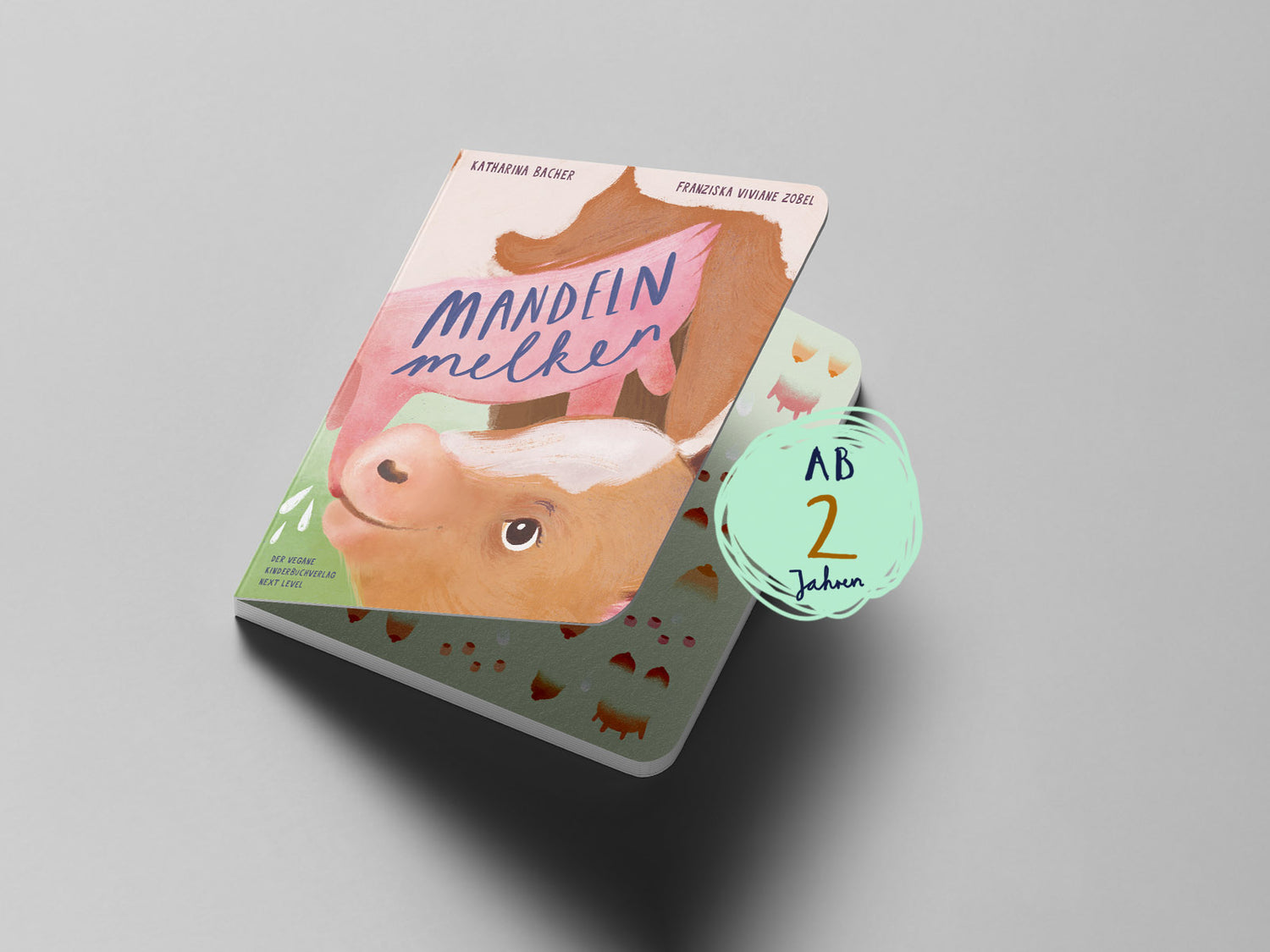 Titel auf dem Buchcover „Mandeln melken“, Illustration eines Kälbchens, das bei seiner Mutter Milch trinkt; darüber der Schriftzug „Mandeln melken“; Altersangabe: ab 2 Jahren.